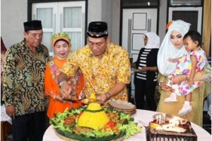 Caleg Golkar, Dudy saat memotong tumpeng saat syukuran bersama masyarakat.