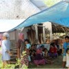 Tampak sejumlah warga transmigrasi lokal sedang bercengkrama di depan rumah yang sudah tidak layak huni.