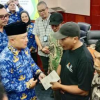 Bupati Kuningan saat menyalurkan BLT DBHCHT kepada wrga secara simbolik.