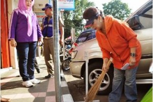 Bupati Kuningan, Hj Utje Ch Suganda ikut membersihkan jalan berbaur dengan warga.